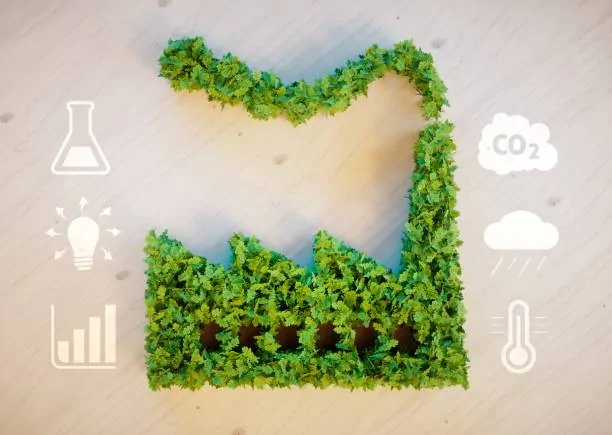Silhouette d'usine en feuillage vert sur fond de bois clair, entourée de pictogrammes CO2, nuage, thermomètre et ampoule