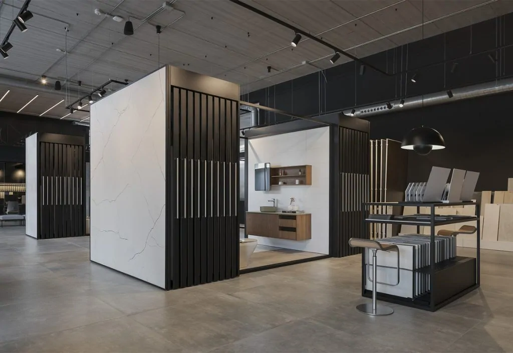 Exposition de carrelage avec grandes plaques effet marbre blanc sur structures à lames noires et présentoir d'échantillons